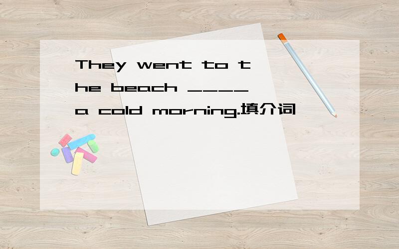 They went to the beach ____ a cold morning.填介词